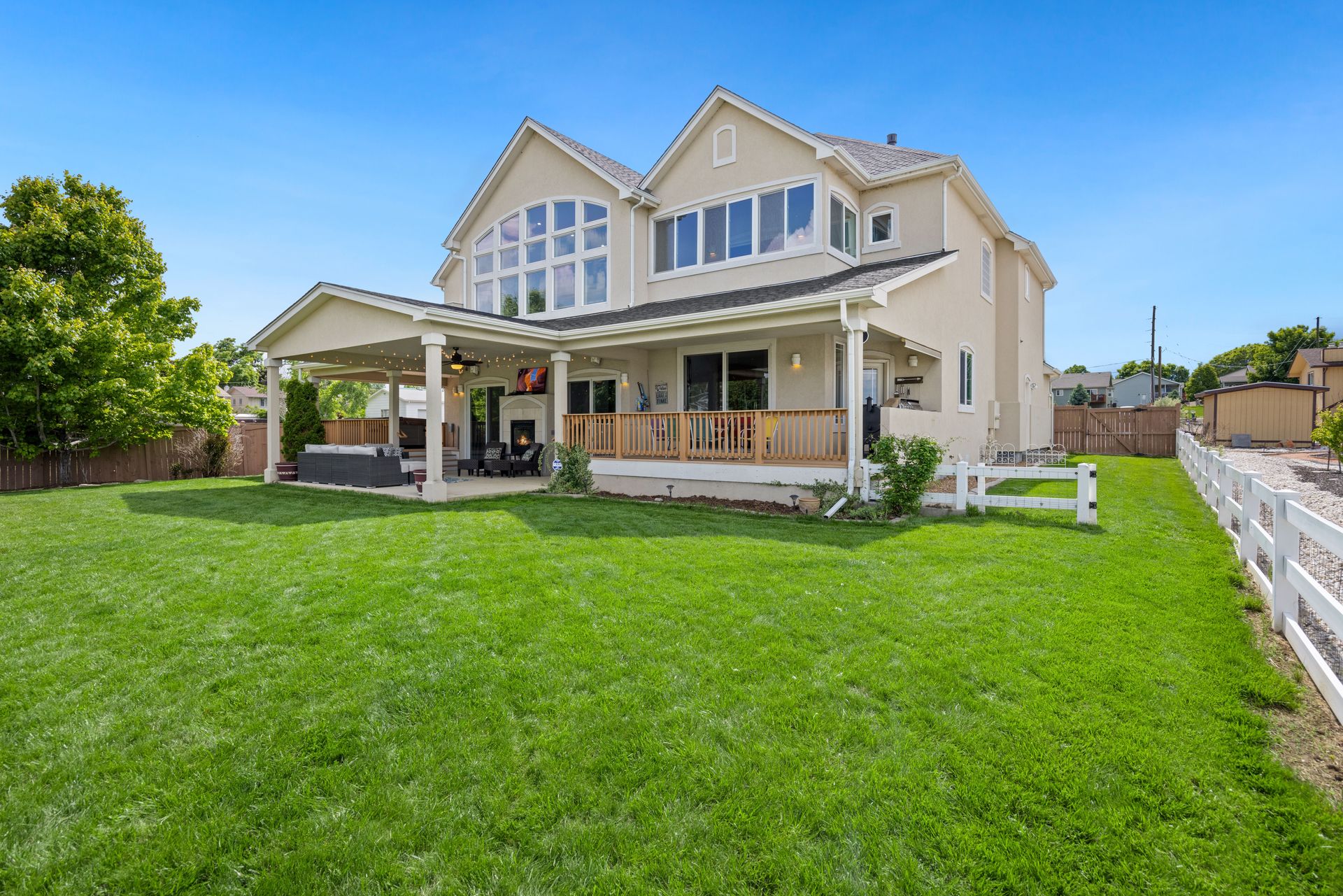 Beautiful two-story suburban house with a large green lawn and porch.